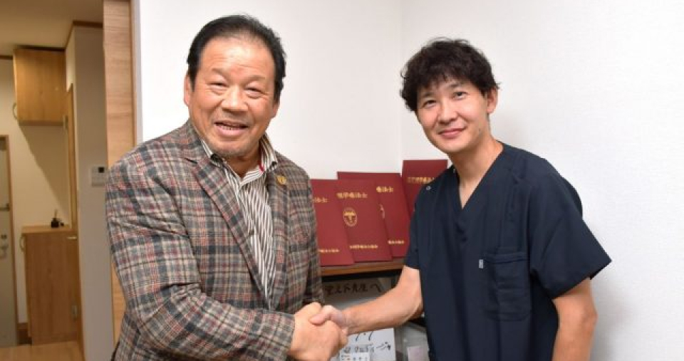 プロレスラーの藤波辰爾選手と握手を交わす院長